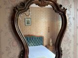 a mirror on the wall above a bed in a room