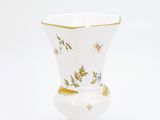 a white vase with a gold trim and flowers on it