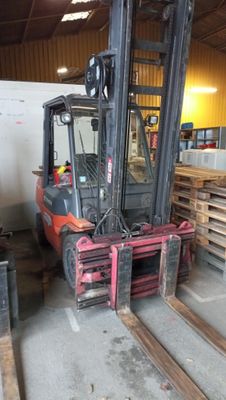 a forklift in a warehouse with pallets of wood