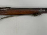 un vieux fusil avec un canon en bois et une poignée en métal