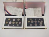 two boxes of coins are sitting next to each other on a table