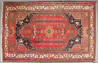 un vieux tapis à fond rouge et orné d'un motif