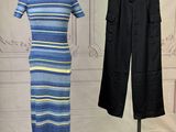 blue and yellow striped dress on a mannequin stand next to a pair of black pants