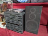 une pile d'enceintes et un lecteur CD posés sur une table
