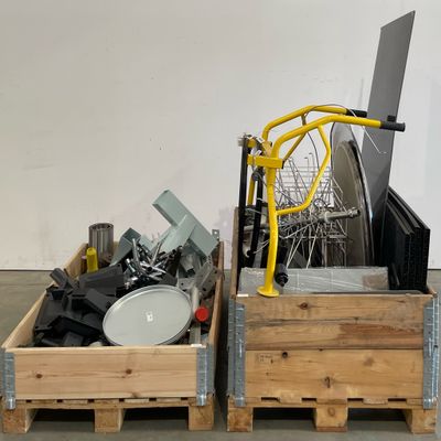 une caisse en bois contenant un ordinateur portable et une pile d'autres objets