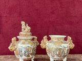 deux vases posés sur une table, avec un mur rouge en arrière-plan