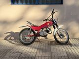 a red motorcycle parked in front of a tan building