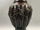 un vase muni d'un couvercle orné d'un motif floral