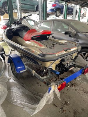 un bateau sur une remorque dans un garage, avec une voiture en arrière-plan