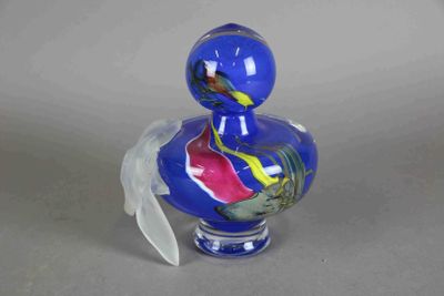un canard en verre bleu orné d'un motif rouge et jaune sur le corps