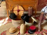 a woman sitting on the floor next to a dresser with hats on it