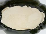 a black bowl with a white substance in it on a table