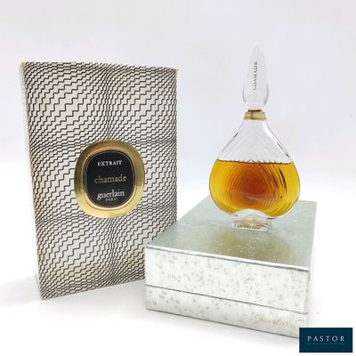 une image représentant un flacon de parfum posé sur un coffret en argent