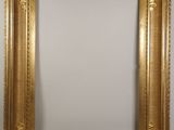 a gold framed mirror with a white background