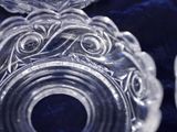 two clear glass candlesticks sitting on a blue cloth