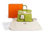an orange and green bag sitting on top of a white bag