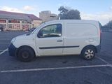 a white van parked in a parking lot in front of a building