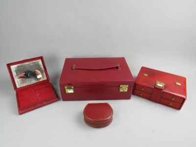 trois valises rouges et une petite boîte sur laquelle figure la photo d'une femme dans un miroir