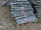 un tas de barres d'acier posé par terre à côté d'un tas de bois