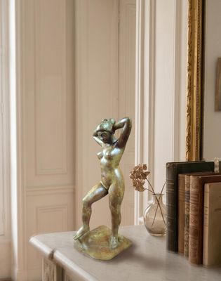 a statue of a woman standing on a table next to a mirror