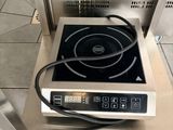 une petite cuisinière surmontée d'un brûleur noir
