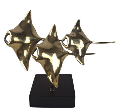a gold sculpture of three stingfishs sitting on top of a black stand