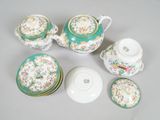 a tea pot, cups and saucer set on a table