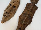 deux morceaux de bois sculpté sont posés sur une surface blanche