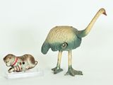 two figurines of a bird and a cat on a white surface