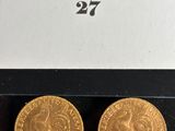 a pair of gold sovereigns in a box on a table