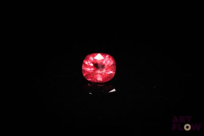 a close up of a red diamond in the dark