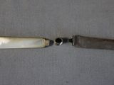 a knife that is sitting next to a knife on a table