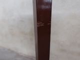 a wooden table with a brown top and a white wall