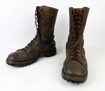 une paire de bottes marron à lacets sur fond blanc
