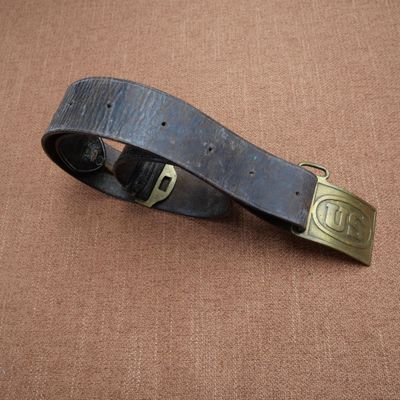 une vieille ceinture avec une boucle en laiton sur fond marron