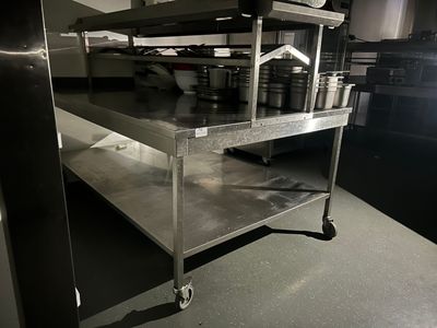 a metal shelf with pots and pans on it in a kitchen