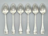 six silver spoons sitting on top of a table next to each other