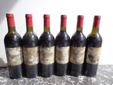 six bouteilles de vin sont alignées sur une table