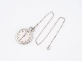 a silver pocket watch and a chain on a white surface