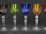 six different colored wine glasses are lined up in a row