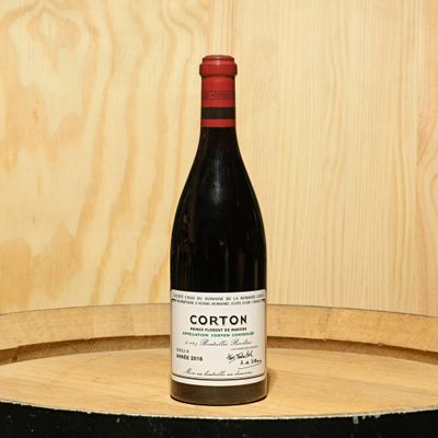 a bottle of wine sitting on top of a barrel