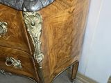 a marble top chest of drawers in the corner of a room