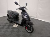 the motor scooter is parked in the garage on the floor