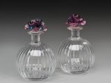 une paire de vases en verre transparent surmontés de fleurs violettes