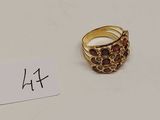 une bague en or sertie de grenats, avec une étiquette indiquant le prix