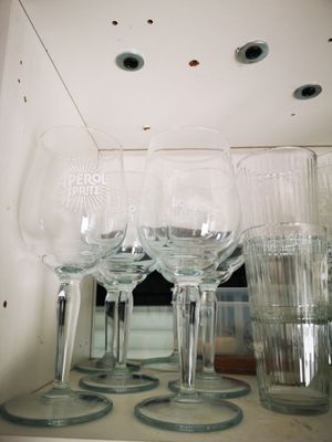 des bouteilles et des verres posés sur une étagère, avec des trous dans le plafond