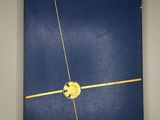 blue book with a yellow circle on the front and a yellow line on the back