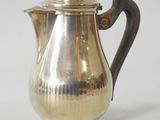 a silver coffee pot sitting on a white surface