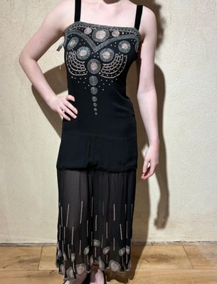 a woman that is posing for a picture in a black dress