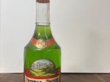 une bouteille contenant un liquide vert posée sur une table en bois